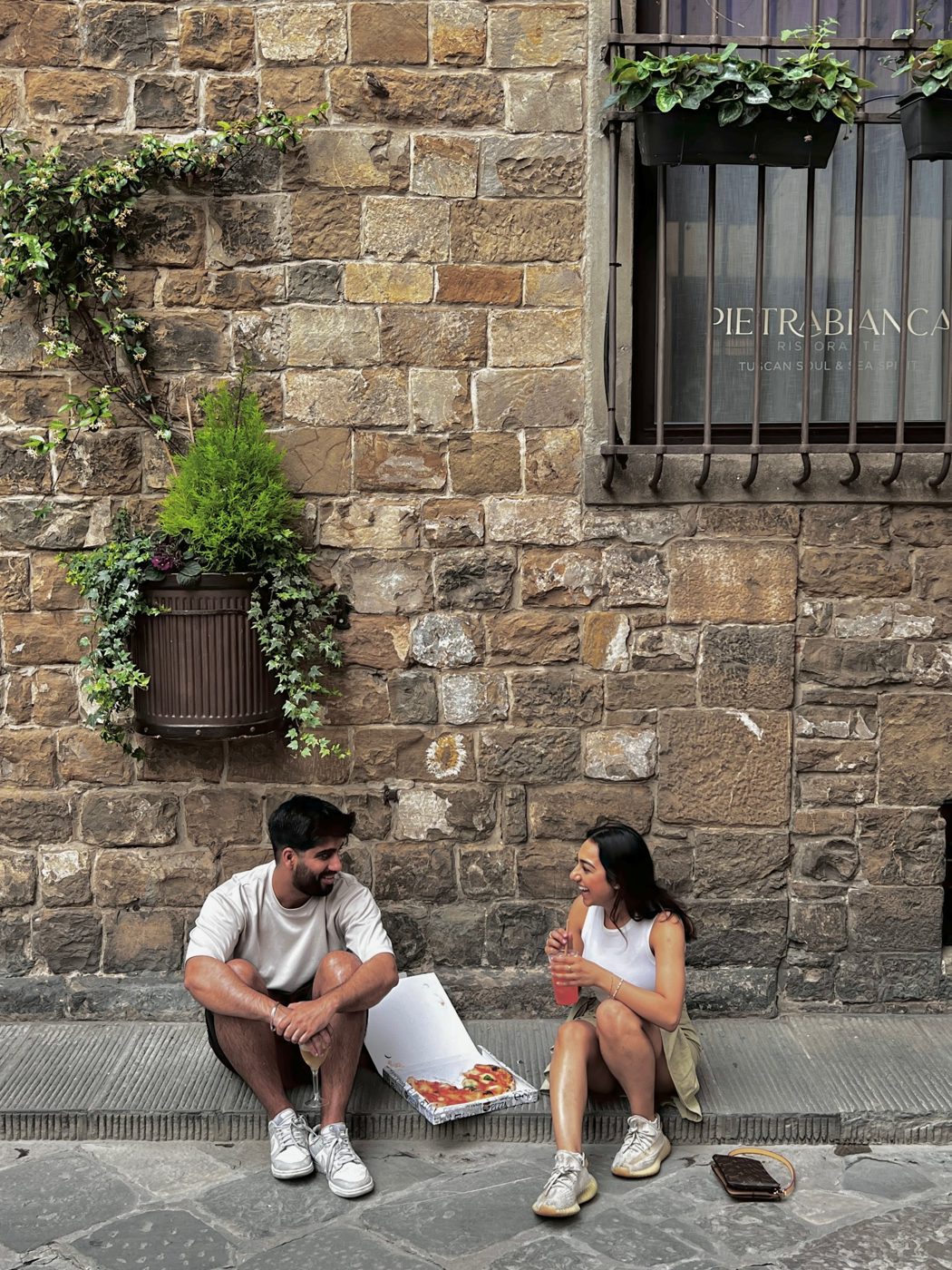 Aman and Ashmeet laughing on a stone step in Italy